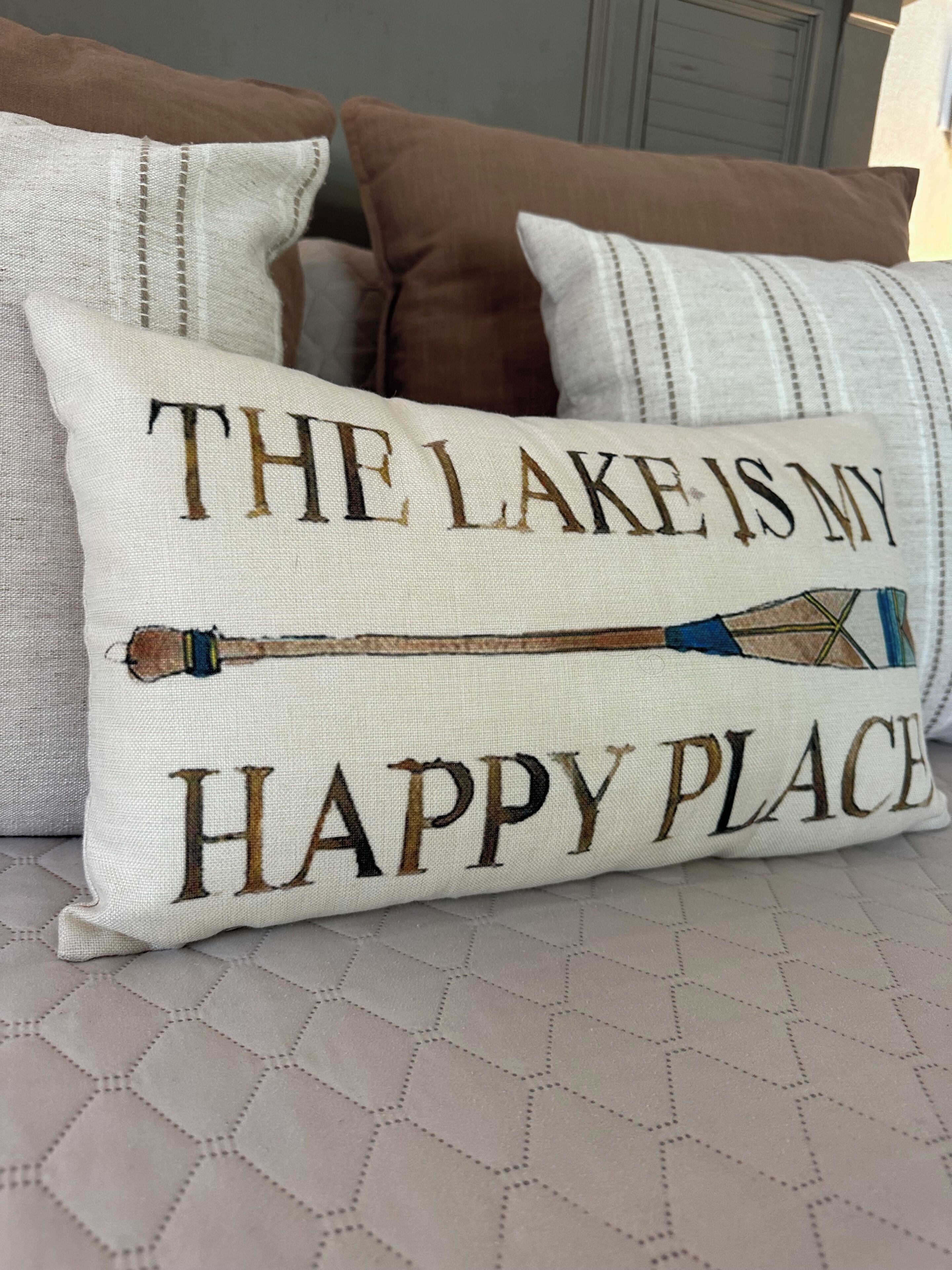 Almohada con texto bordado y diseño de caña de pescar.
