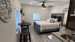 A compact bedroom with a bed, bedside table, and a ceiling fan. - Greers Ferry Lakefront Getaway - easy lake access (Higden)