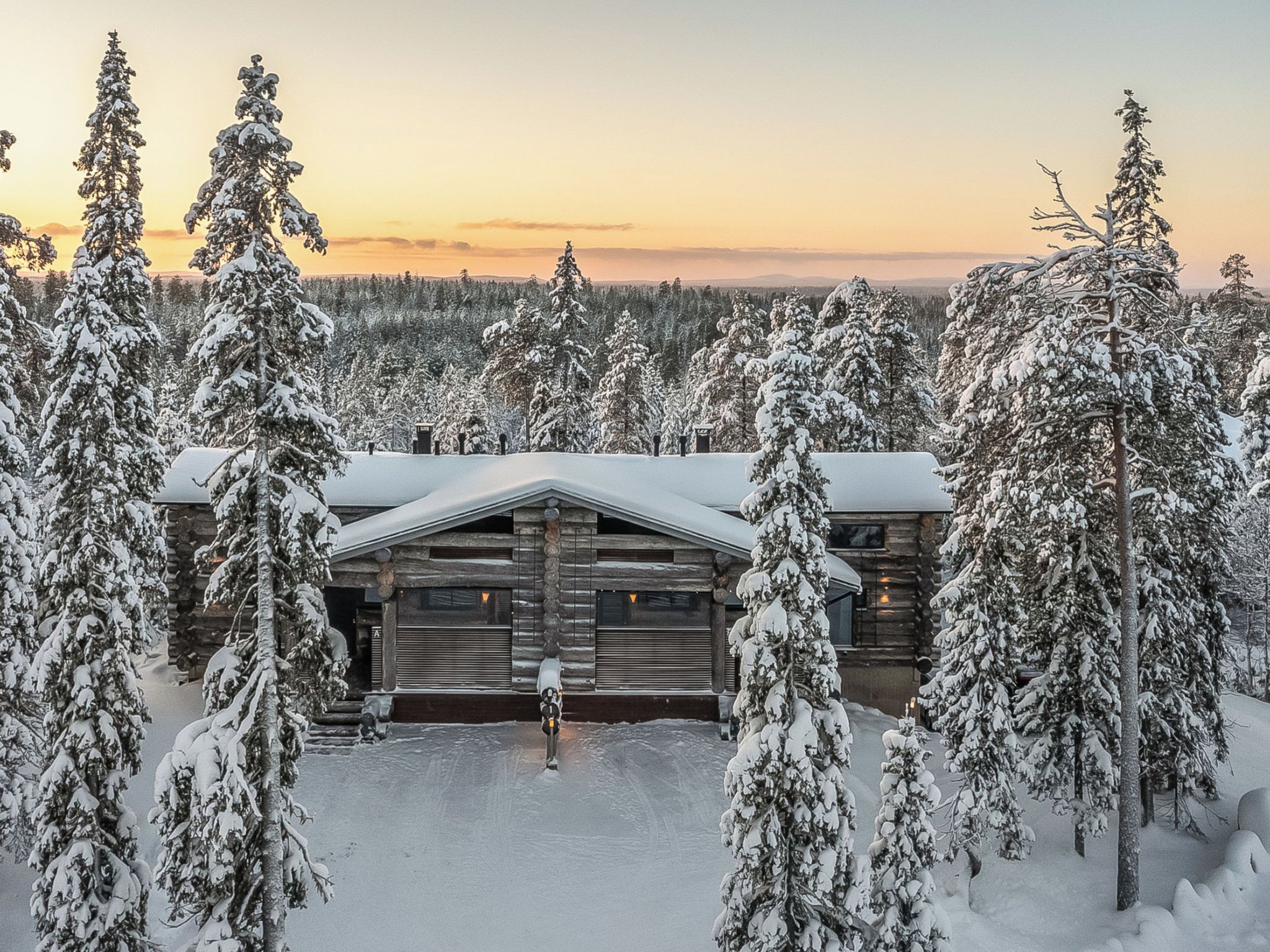 A log cabin surrounded by snow-covered trees.