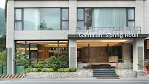 A modern hotel building with a sign reading "Gamalain Spring Hotel". - Gamalan FL Spring Hotel (Jiaoxi)