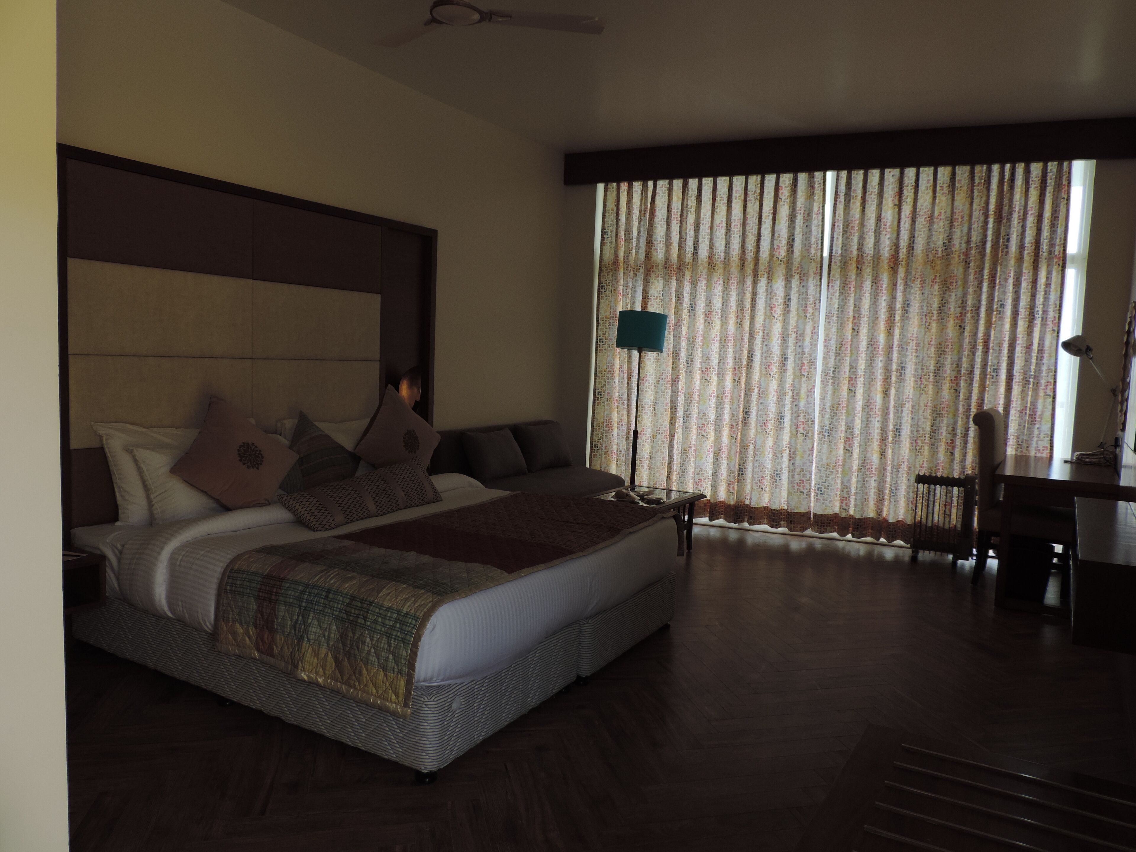 Una habitación de hotel con una cama grande, un escritorio y una silla.