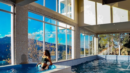 Una piscina techada, sillones reclinables de piscina