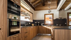 Eine moderne Küche mit Holzschränken, Edelstahlgeräten und einer großen Kochinsel.