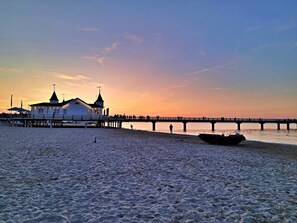 A pier extending into calm waters with a building featuring a tower and a smaller structure at its end. - Ostseepark Waterfront Galeone 44 - Galeone 44 (Heringsdorf)