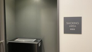 A smoking area with a sign indicating its location. - Kuretake Inn Premium Meieki Minami (Nagoya)