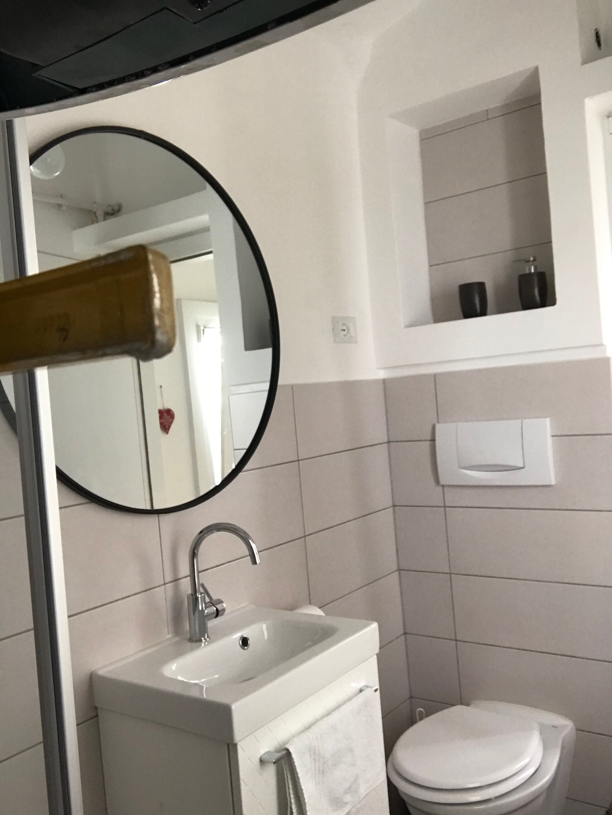 A bathroom with a white sink, a toilet, and a mirror.