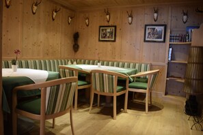 Un restaurant aux murs en bois, avec des banquettes à rayures vertes et des tables.