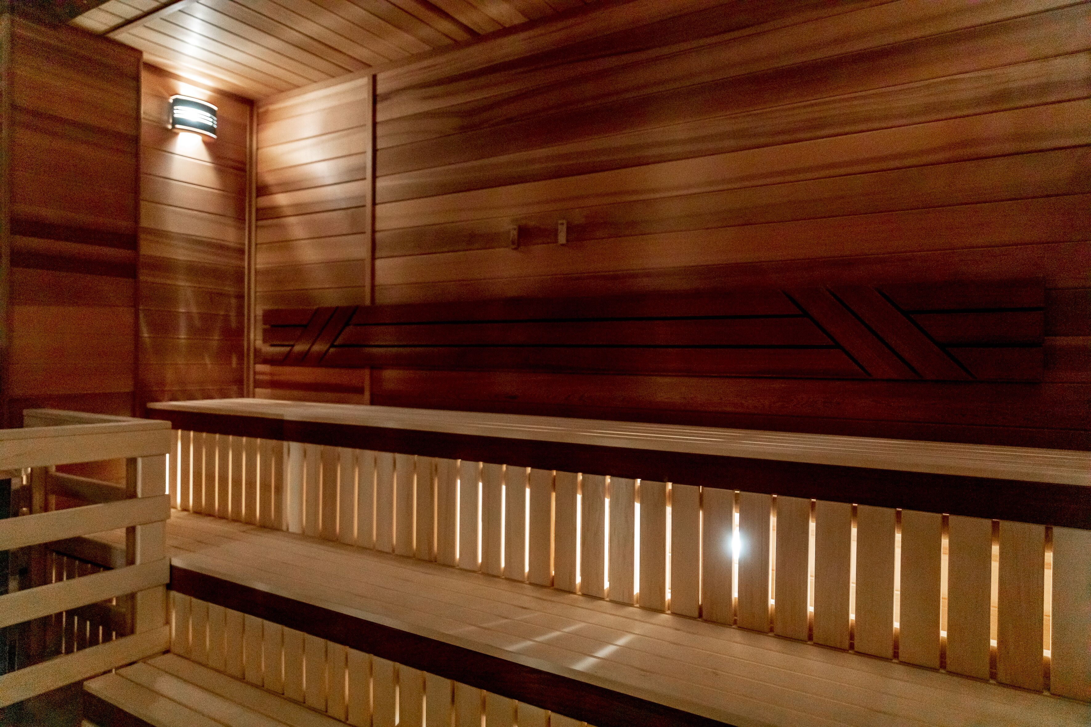 Un sauna avec des murs et des bancs en bois.