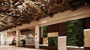 Un vestíbulo moderno con techo de madera, una recepción y una pared vertical con jardín.