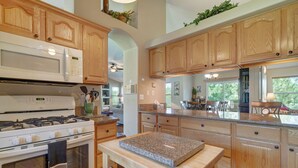 Une cuisine spacieuse avec des meubles en bois, un plan de travail en granit et un îlot central.