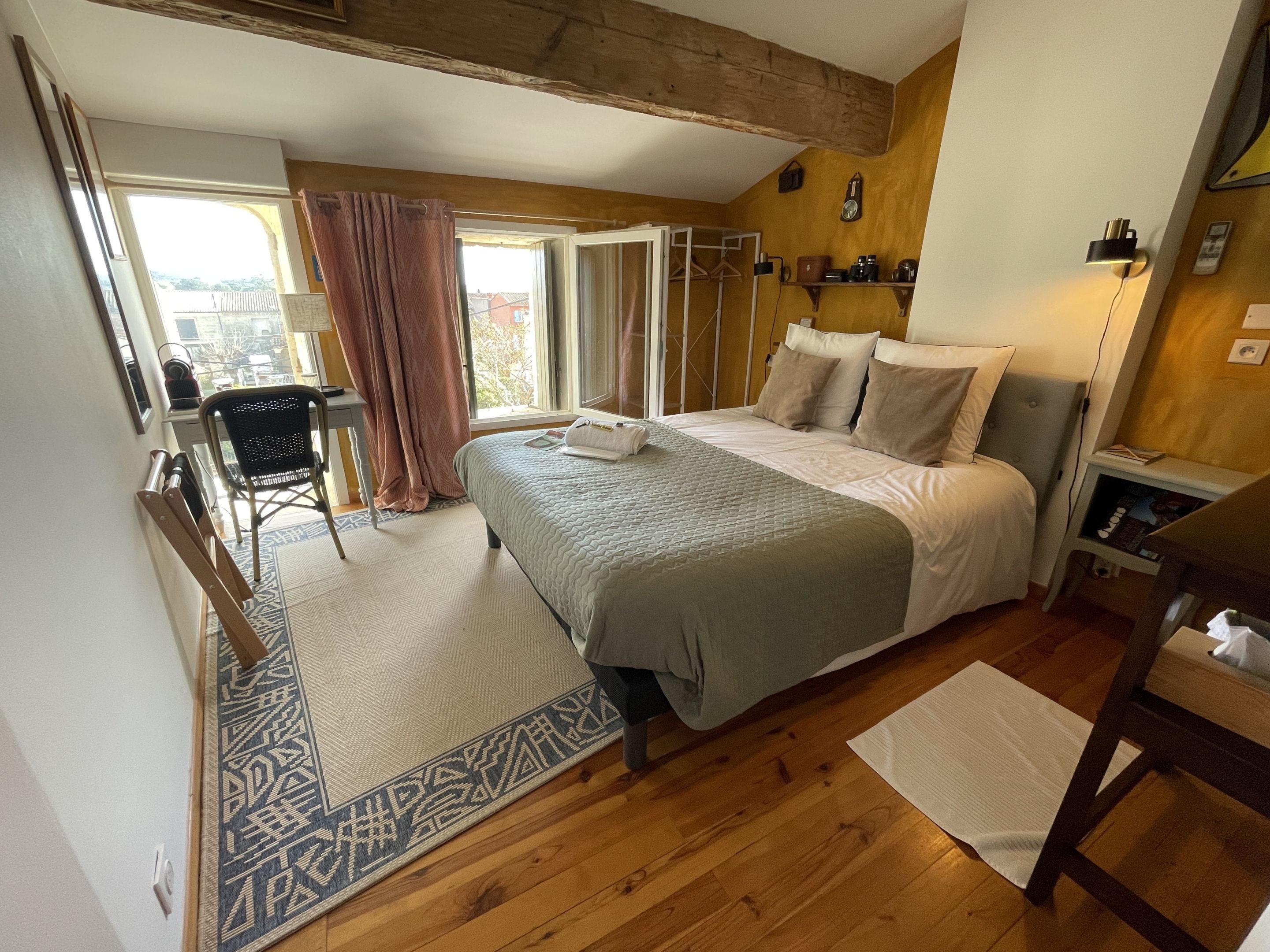 A bedroom with a bed, bedside table, and a chair.