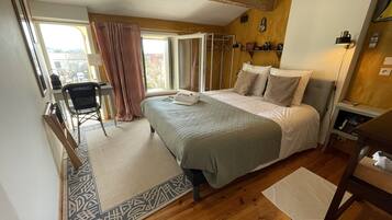 A bedroom with a bed, bedside table, and a chair.