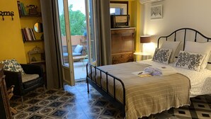 A bedroom with a bed, a chair, a desk, a bookshelf, and a window. - Lo Componaïro (Pouzols)