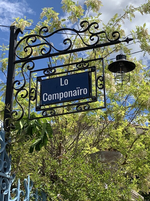 A sign with the text "Lo Componaire" mounted on a decorative metal structure.