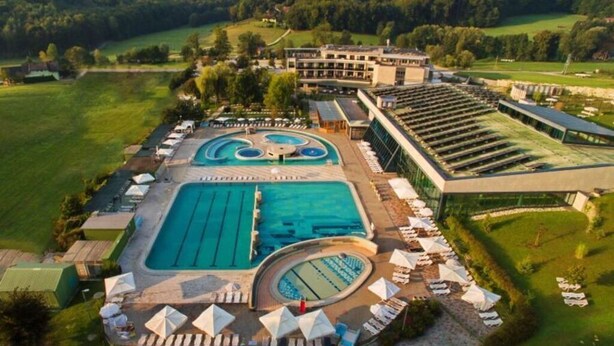 Un hotel con varias piscinas, tumbonas y un amplio espacio al aire libre.