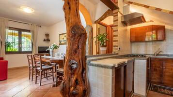 Een koelkast, een magnetron, een kookplaat, kookgerei, borden en bestek