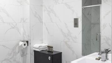 Un baño moderno con inodoro, lavamanos y espejo.