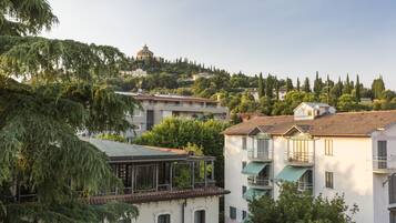 A residential area with multi-story buildings, some with balconies, and a hilltop structure in the background.