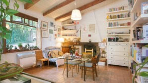 A cozy room with a dining table, chairs, a bookshelf, and a fireplace. - Entire house in the countryside with garden and sea view (Pesaro)
