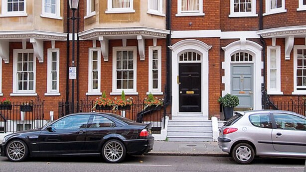 A row of red brick townhouses with white window frames and a central black door. - Chelsea - Draycott Place apartments by Viridian Apartments (London)