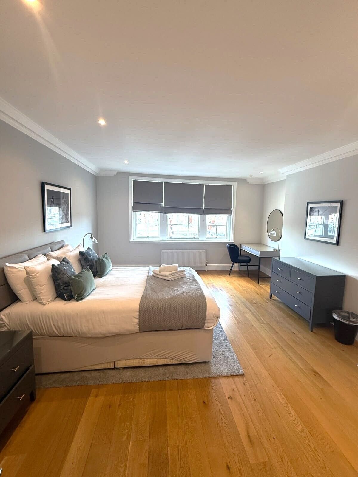 A bedroom with a bed, a desk, a chair, and a radiator.