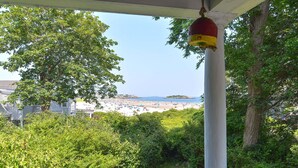 A view of a beach with a white building in the foreground and a clear sky.