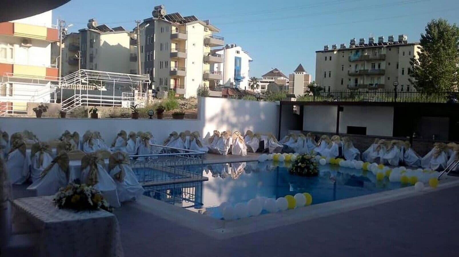 A rooftop pool area with a seating arrangement around the pool, surrounded by buildings.