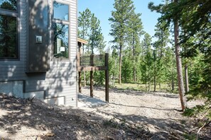 Guests can enjoy a serene outdoor space surrounded by trees and a dirt path leading to a bench.