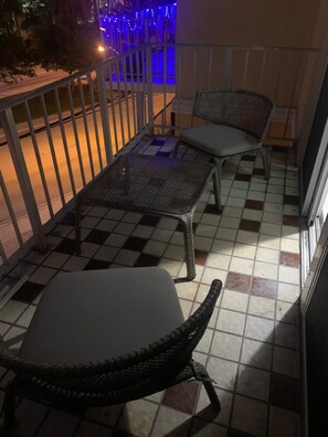 Relax on the balcony with two comfortable chairs and a small table.