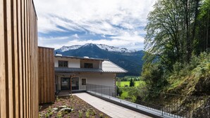 Un edificio moderno con balcón que da a un paisaje montañoso.