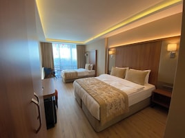 Habitación de hotel con dos camas, un escritorio y vistas a la ciudad.