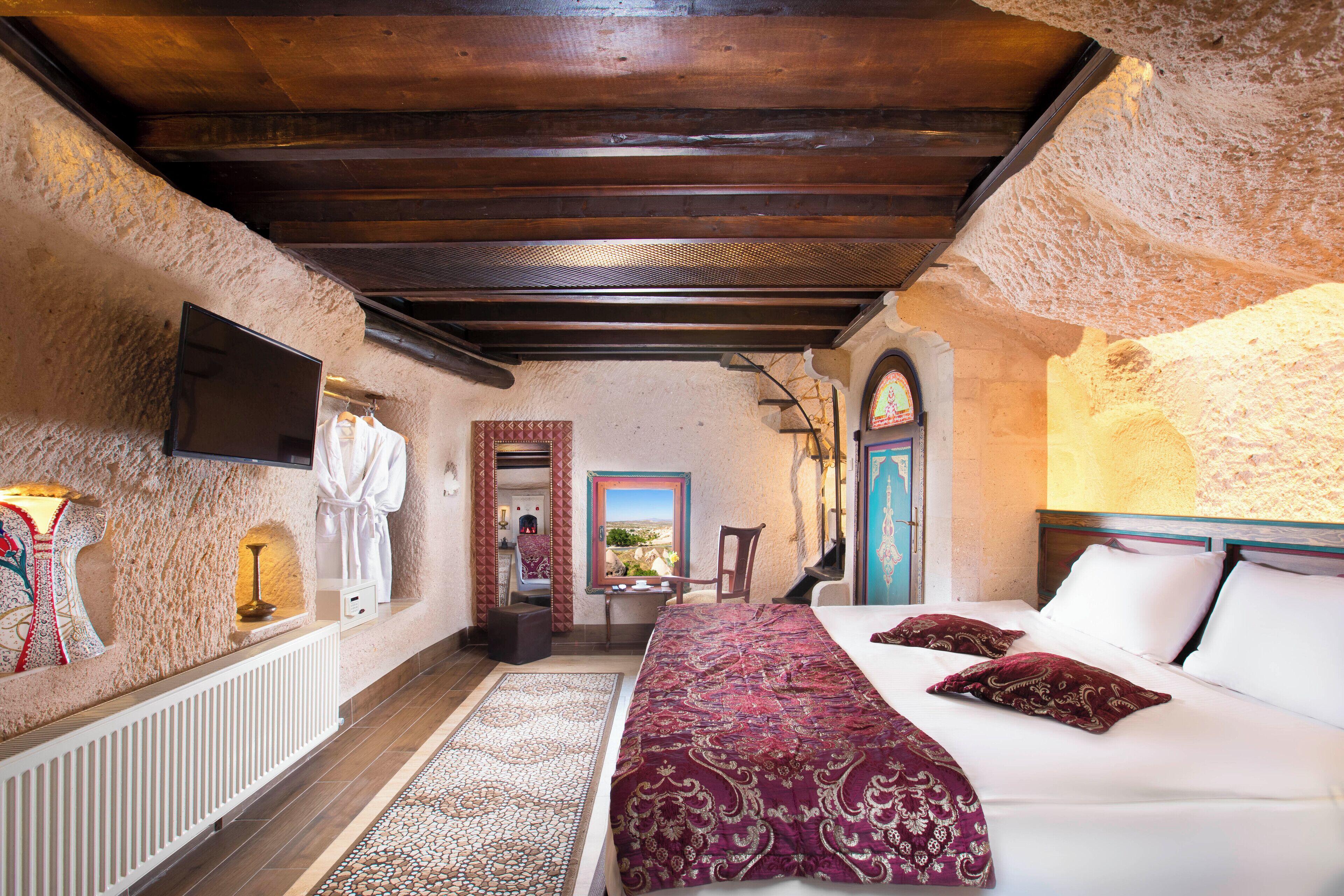 Una habitación con cama, televisión, ventana y puerta.