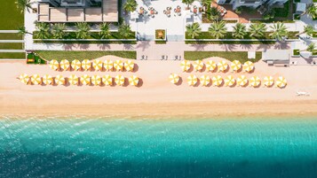 Privat strand, solstolar, parasoller och volleyboll