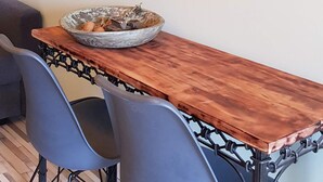 Un coin repas comprenant une table en bois, deux chaises et un élément décoratif mural.