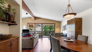 A dining area with a wooden table and chairs, a television, and a view of the outdoors through large sliding doors. - Great Views, Summer Resort Activities! (Durango)
