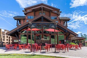 A building with a ski resort name, outdoor seating with red chairs, and a clear sky. - Great Views, Summer Resort Activities! (Durango)