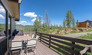 A wooden deck with outdoor seating, overlooking a mountainous landscape and a cabin. - Great Views, Summer Resort Activities! (Durango)