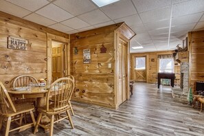 A cabin interior with a wooden dining table and chairs, a billiards table, and a fireplace with a deer decoration. - ER16 - Mountain Blessing | Great location - Close to town! (Pigeon Forge)