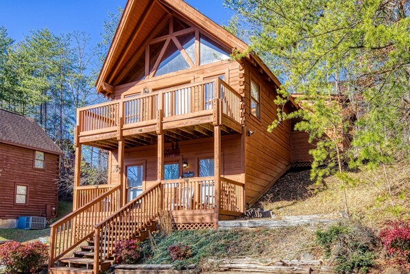 A wooden cabin with a balcony, a staircase, and a 'Welcome' sign. - ER16 - Mountain Blessing | Great location - Close to town! (Pigeon Forge)