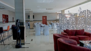 A spacious lobby with a bar area, seating arrangements, and a decorative partition. - Hôtel La Rose Blanche Korhogo (Korhogo)
