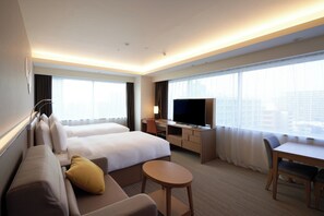 A hotel room with two beds, a sofa, a desk, a TV, and a city view. - Holiday Inn & Suites Shin Osaka by IHG (Osaka)