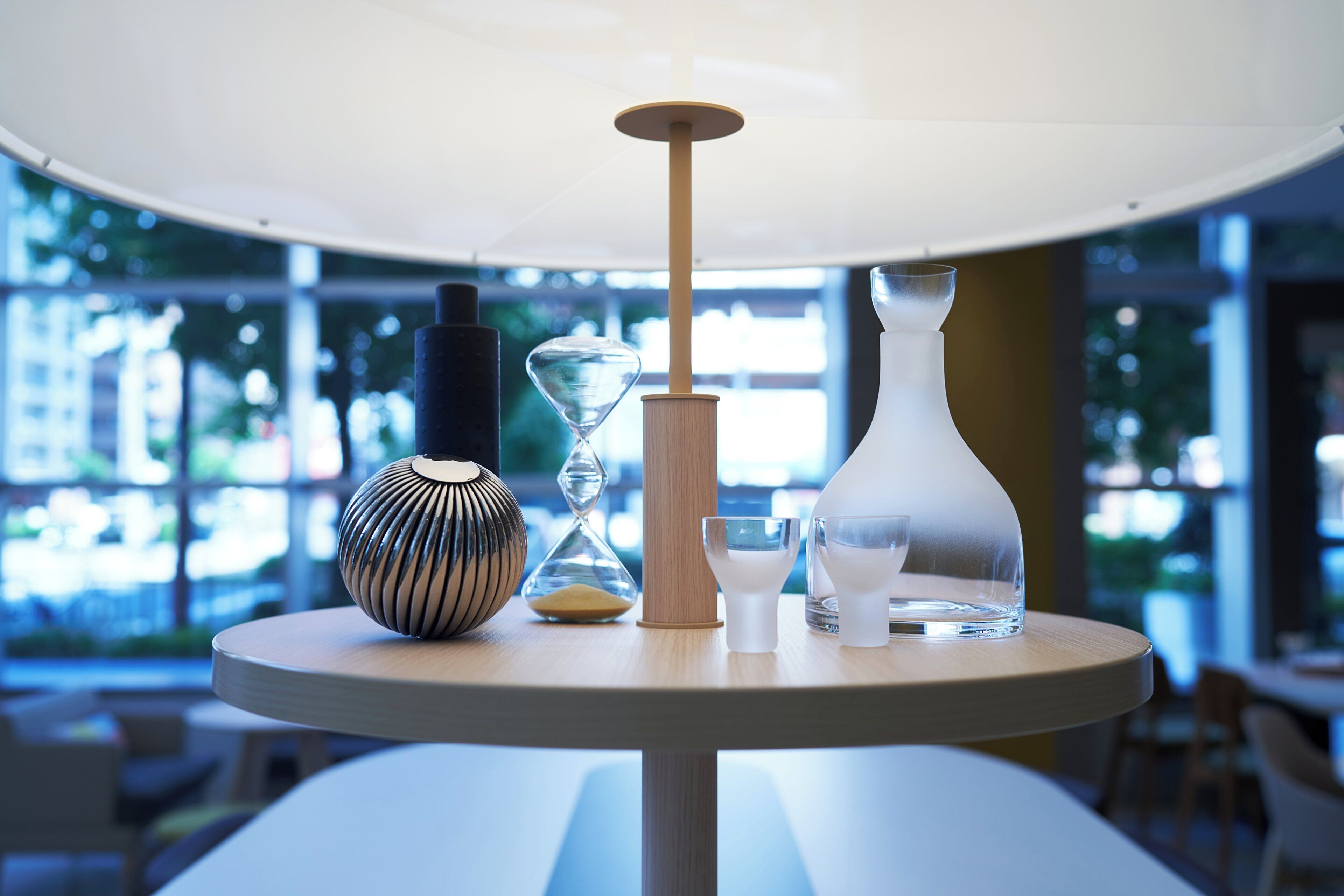 A round table with a variety of glassware and a vase.