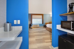 A hotel room with a kitchenette, a bed, a desk, and a window with blinds. - Holiday Inn Express & Suites Wooster by IHG (Wooster)