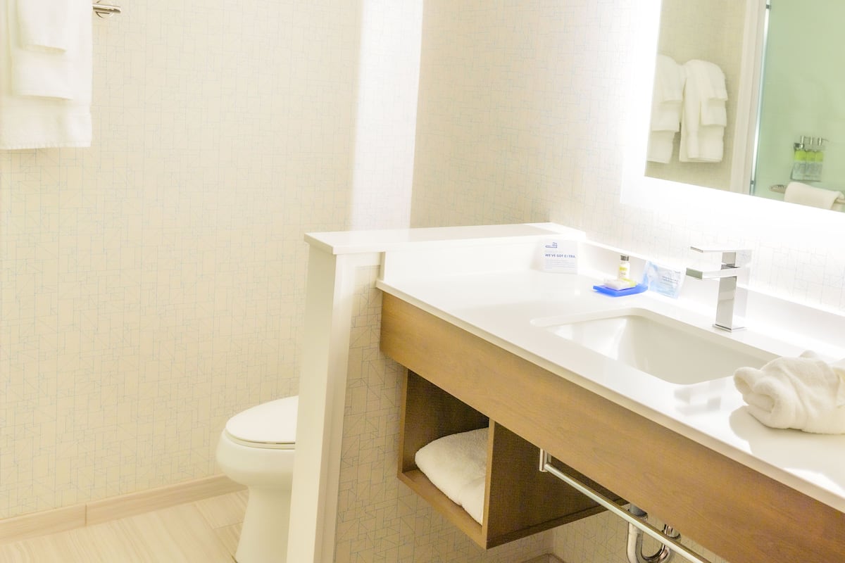 Ein Badezimmer mit Toilette, Waschbecken und Spiegel.
