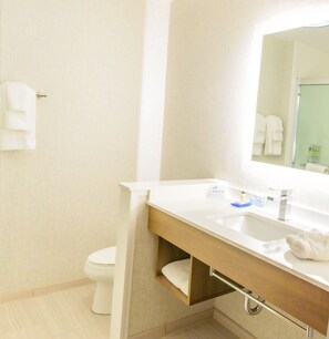 Une salle de bain avec des toilettes, un lavabo et un miroir.