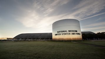 El exterior del Museo Nacional de la Fuerza Aérea de los Estados Unidos, con un gran edificio cilíndrico y una estructura en forma de cúpula.