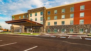 A hotel with a stone facade, multiple floors, and a covered entrance. - Holiday Inn Express & Suites Dayton East - Beavercreek by IHG (Dayton)