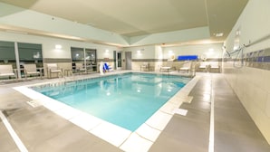 An indoor swimming pool with clear water, tiled walls, and several lounge chairs around the perimeter. - Holiday Inn Express & Suites Dayton East - Beavercreek by IHG (Dayton)