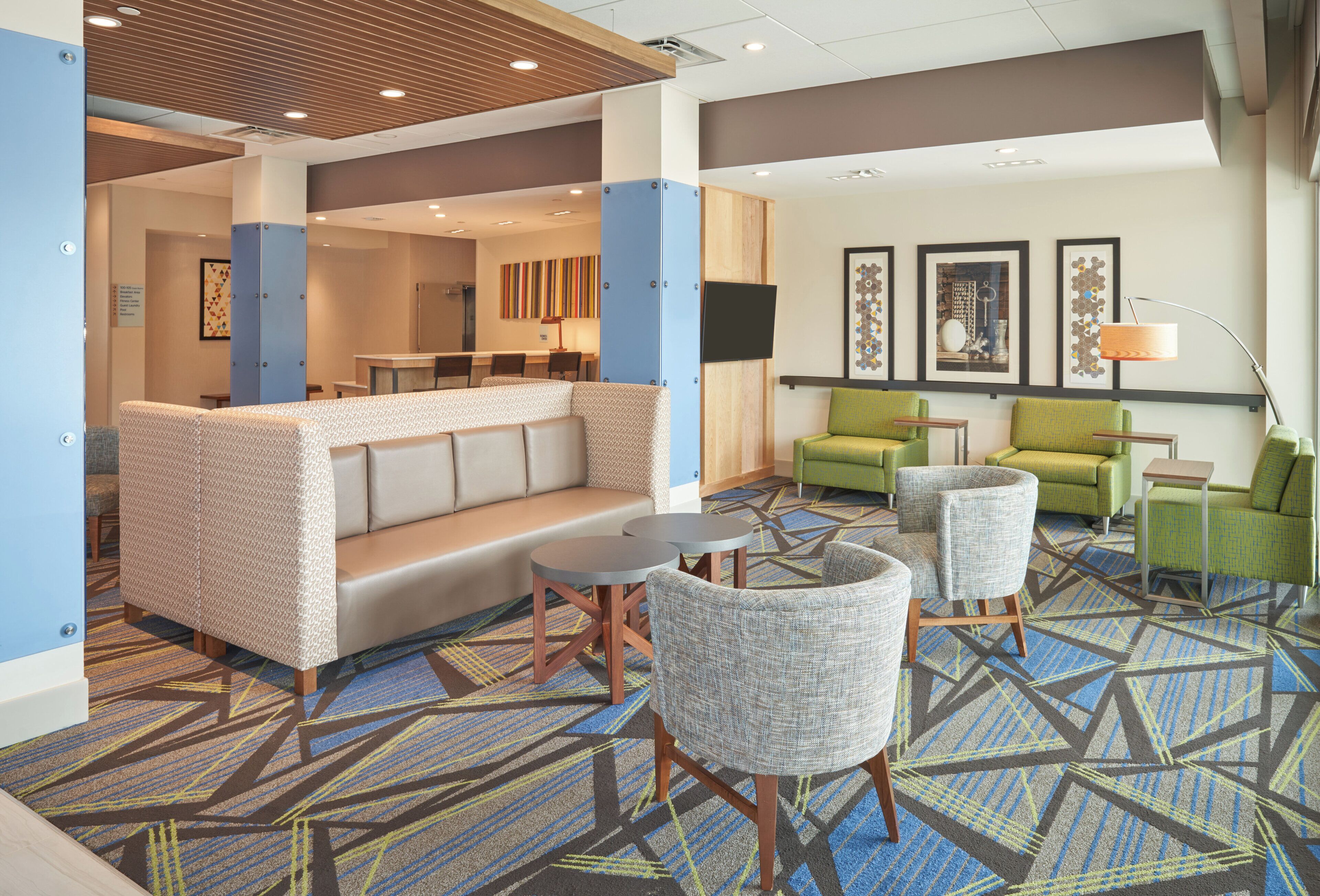A hotel lobby with a seating area, a reception desk, and a bar.