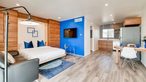 A modern bedroom with a large bed, bedside tables, and a desk with a chair. - Hollywood Studios in Downtown Phoenix (Phoenix)